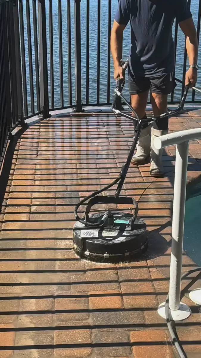 Surface cleaner removing dirt and algae from a paver pool deck in Central Florida